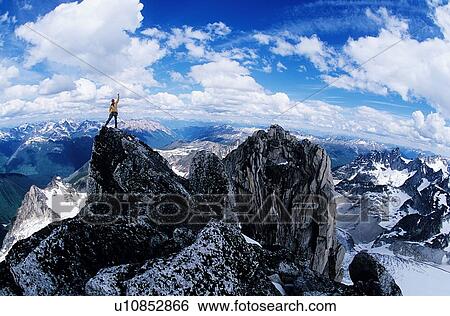 Stock Photograph - Male hiker celebrating at the top of the mountain. Fotosearch