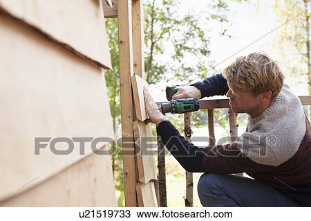 Man building treehouse in garden View Large Photo Image Stock Image - Man building treehouse in garden. Fotosearch