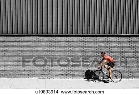 Man cycling on bicycle in city View Large Photo Image Picture - Man cycling on bicycle in city. Fotosearch