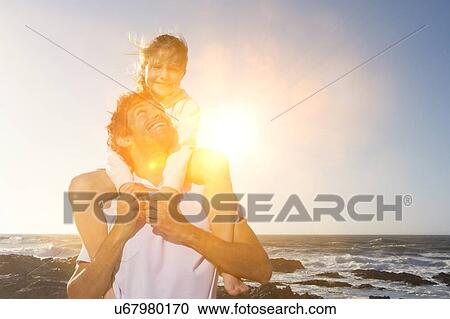 Man Giving Daughter Piggyback Ride on the beach View Large Photo Image Stock Image - Man Giving Daughter Piggyback Ride on the beach. Fotosearch