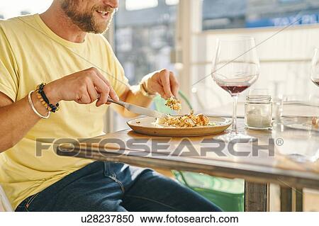 Stock Image - Man having meal in restaurant. Fotosearch