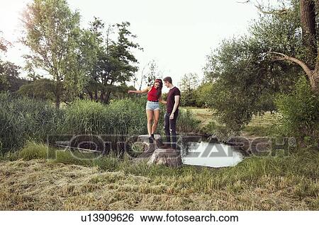 Man helping woman balance on logs in pond, Wilhelminenberg, Vienna, Austria View Large Photo Image Stock Photograph - Man helping woman balance on logs in pond, Wilhelminenberg, Vienna, Austria. Fotosearch