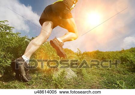 Stock Photography - Man hiking in countryside, low section. Fotosearch