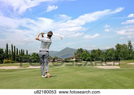Stock Image - Man playing golf on golf course. Fotosearch