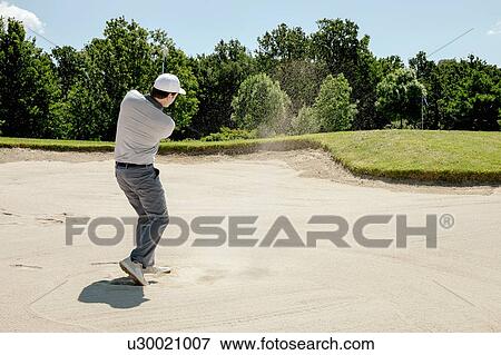 Stock Photo - Man playing golf on golf course. Fotosearch