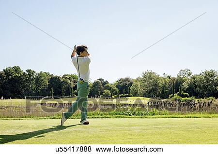 Stock Photo - Man playing golf on golf course. Fotosearch