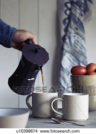 Picture - Man pouring coffee into mug. Fotosearch