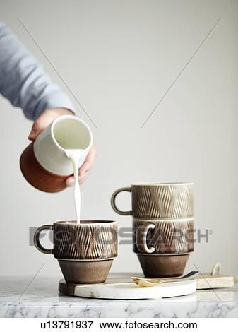 Man pouring milk into mug View Large Photo Image Stock Photo - Man pouring milk into mug. Fotosearch