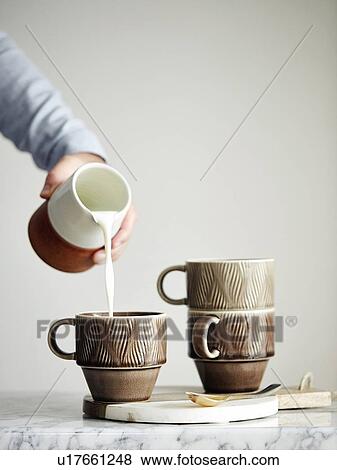 Man pouring milk into mug View Large Photo Image Stock Photo - Man pouring milk into mug. Fotosearch