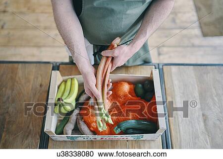 Stock Image - Man preparing vegetables in kitchen. Fotosearch