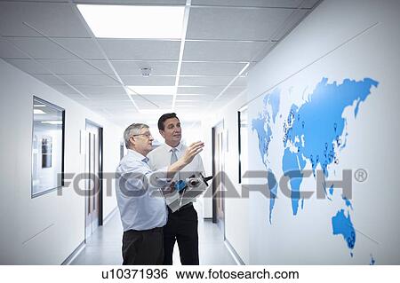 Manager and engineering designer discussing product and world map in medical scientific factory View Large Photo Image Stock Photograph - Manager and engineering designer discussing product and world map in medical scientific factory. Fotosearch