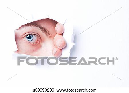 Mans blue eye peering through through ripped paper View Large Photo Image Stock Photo - Mans blue eye peering through through ripped paper. Fotosearch