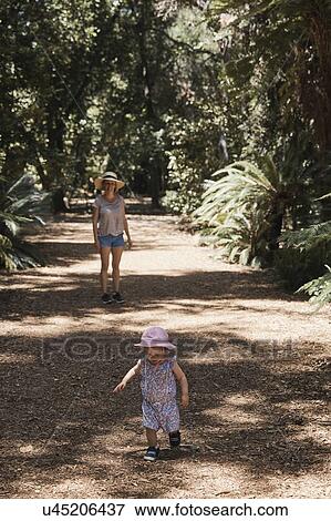 Mother and baby girl taking walk through forest View Large Photo Image Stock Photo - Mother and baby girl taking walk through forest. Fotosearch