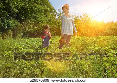 Stock Photo - Mother and daughter in strawberry field. Fotosearch