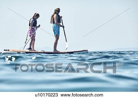 Stock Image - Mother and daughter paddling in sea, Paleros, Greece. Fotosearch
