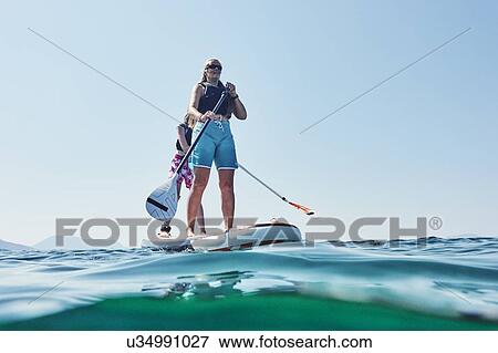 Stock Photo - Mother and daughter paddling in sea, Paleros, Greece. Fotosearch