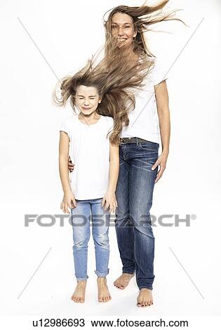 Stock Image - Mother and daughter with flying hair, white background. Fotosearch