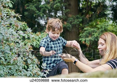 Stock Photo - Mother playing with toddler in park. Fotosearch