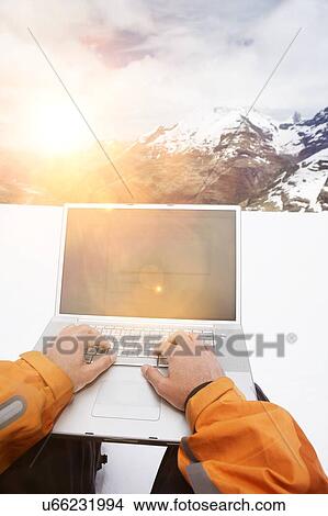 Picture - Mountaineer working remote from laptop. Fotosearch