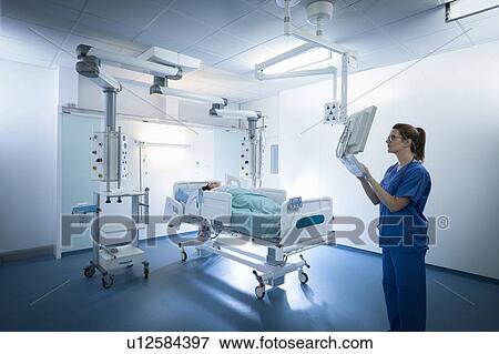 Nurse inspecting screen in intensive care unit in hospital setting View Large Photo Image Stock Photo - Nurse inspecting screen in intensive care unit in hospital setting. Fotosearch