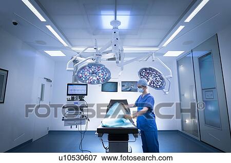 Stock Photo - Nurse preparing operating theatre in hospital setting. Fotosearch
