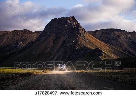 Stock Photo - Off road vehicle driving towards mountain ranges, Landmannalaugar, Highlands, Iceland. Fotosearch