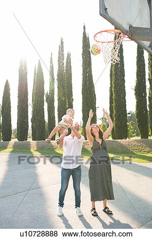 Parents with son playing netball in park View Large Photo Image Stock Photo - Parents with son playing netball in park. Fotosearch