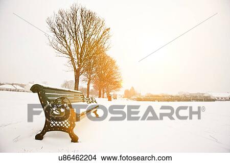Park bench and park covered in snow View Large Photo Image Picture - Park bench and park covered in snow. Fotosearch