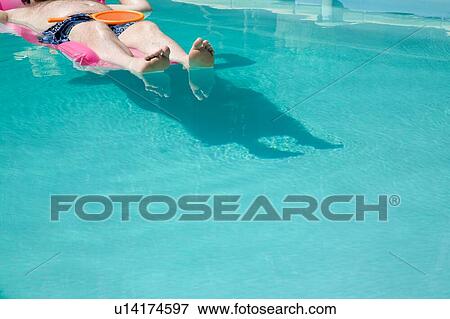 Stock Photo - Person floating in pool. Fotosearch