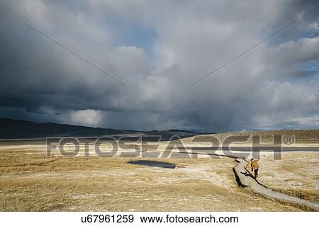 Stock Photo - Person walking on dirt road in countryside, Mammoth, California, USA. Fotosearch