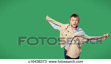 Stock Image - Portrait of amazed young man with jacket over green background. Fotosearch
