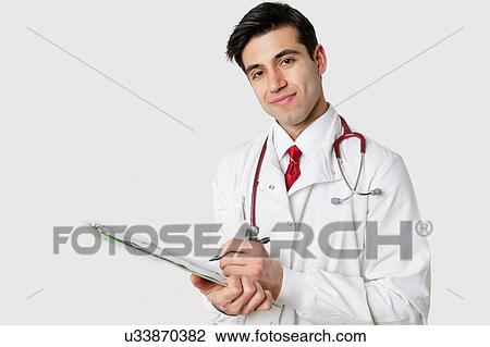 Stock Image - Portrait of an Indian doctor writing prescription. Fotosearch