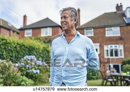 Stock Photo - Portrait of happy man in his garden. Fotosearch