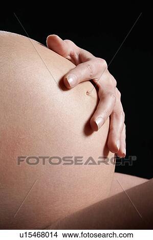 Picture - Pregnant woman holding baby bump. Fotosearch