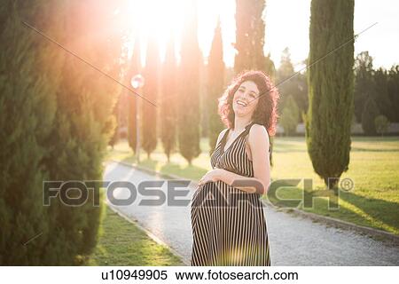 Pregnant woman resting hand on belly in park View Large Photo Image Stock Photography - Pregnant woman resting hand on belly in park. Fotosearch