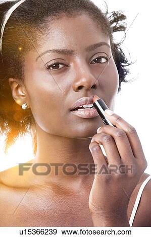 Pretty Black woman applying lipstick View Large Photo Image Stock Photo - Pretty Black woman applying lipstick. Fotosearch