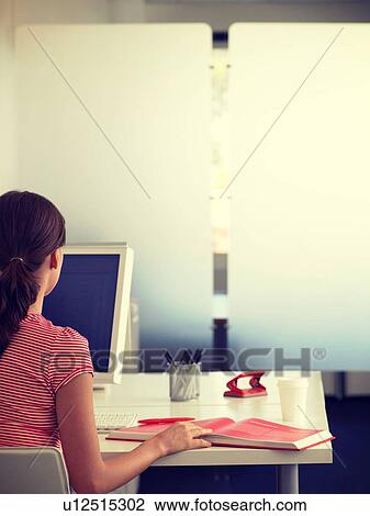Rear view of woman working at her home office View Large Photo Image Stock Image - Rear view of woman working at her home office. Fotosearch