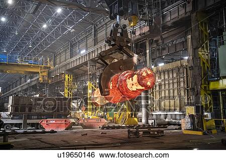 Stock Photograph - Red hot steel ingot in forge in steelworks. Fotosearch
