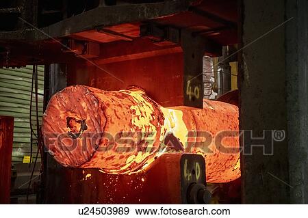 Stock Photo - Red hot steel ingot in steel press in steelworks. Fotosearch
