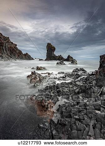 Stock Image - Rock formations in ocean, Vesturland, Iceland. Fotosearch