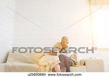 Picture - Senior Couple Hugging on Sofa. Fotosearch