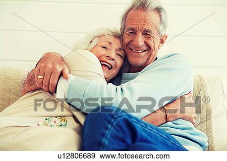 Stock Photo - Senior Couple Hugging on Sofa. Fotosearch