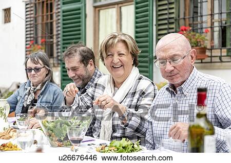 Stock Photograph - Senior couples at outdoor family lunch, Florence, Italy. Fotosearch