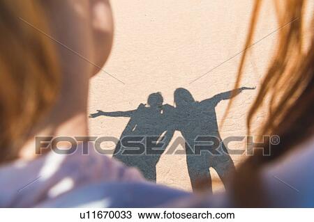 Stock Image - Shadow of two people on sand. Fotosearch