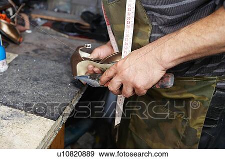 Stock Photo - Shoemaker Repairing High Heel Shoe. Fotosearch