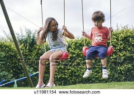 Sister and younger brother on swings in garden View Large Photo Image Picture - Sister and younger brother on swings in garden. Fotosearch