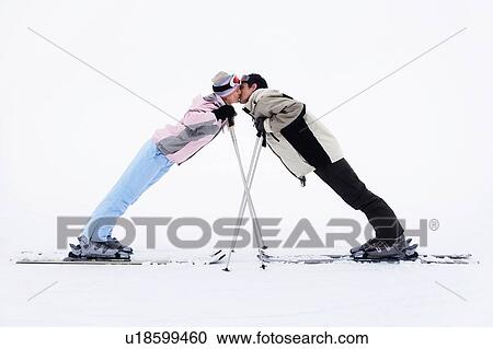 Stock Image - Skiing couple kissing on mountains. Fotosearch