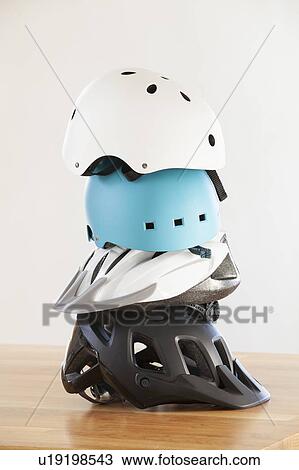 Stock Image - Stack of cycling helmets for children and adults. Fotosearch