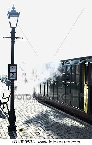 Stock Image - Steam train stopping at station. Fotosearch