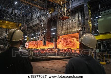 Steelworkers watching red hot steel ingots being craned out of furnace in steelworks View Large Photo Image Stock Photo - Steelworkers watching red hot steel ingots being craned out of furnace in steelworks. Fotosearch